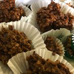 Chocolate-covered rice bubbles sit in white patty cases, looking luscious